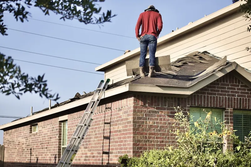 Professional roofer working on a residential roof in Bellerose